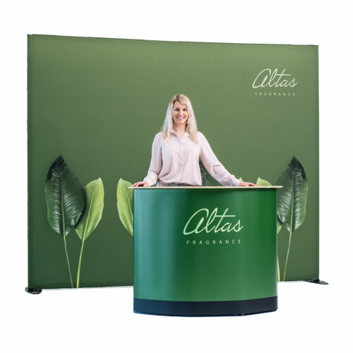 Kvinne bak Altas Fragrance-stand med grønn bakgrunn.